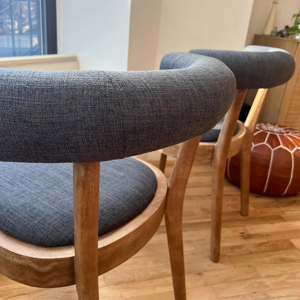 rearview of navy upholstery backrests on solid wood modern dining chairs