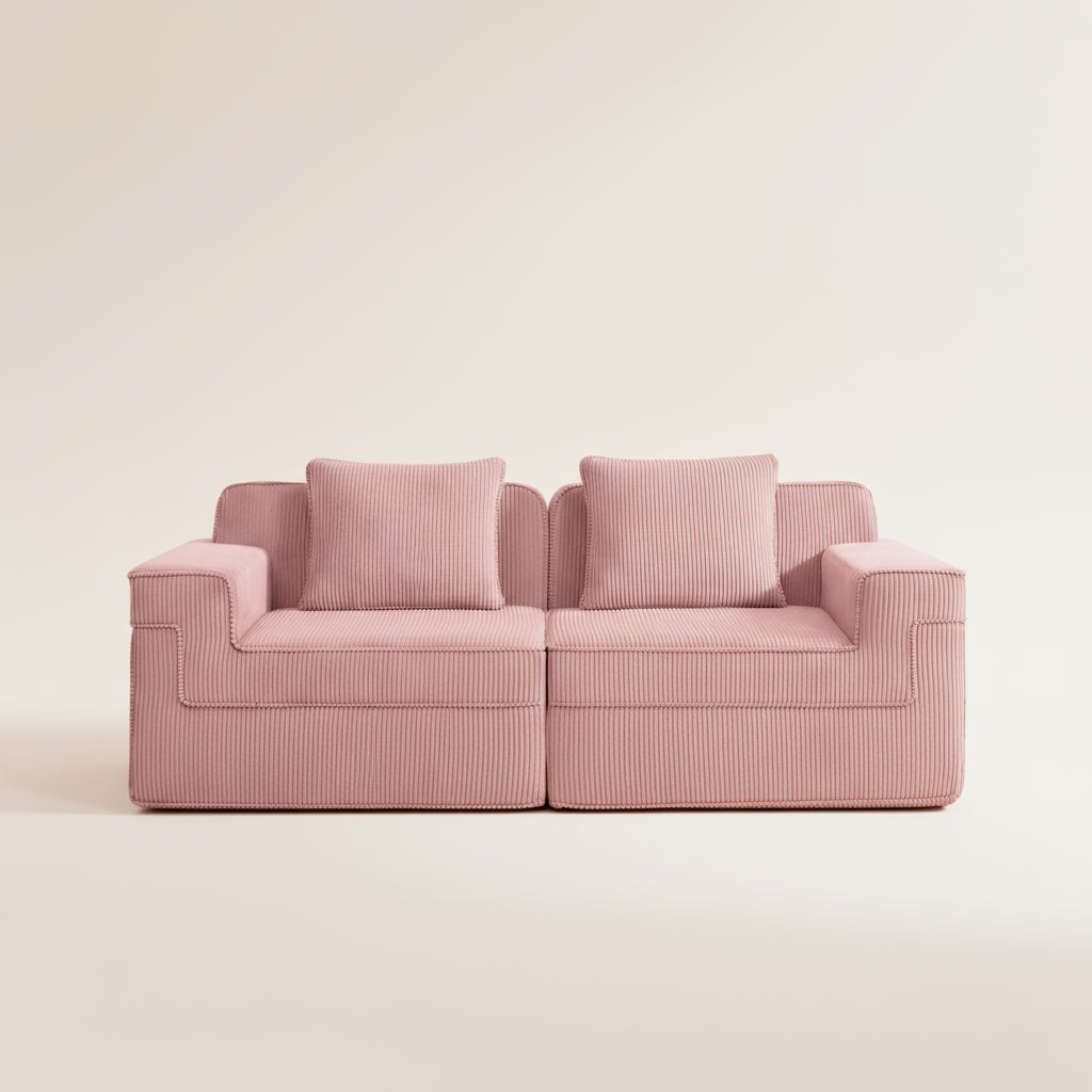 commercial studio photograph of the boneless couch in pink showing the plush corduroy fabric deep seats and two pillows