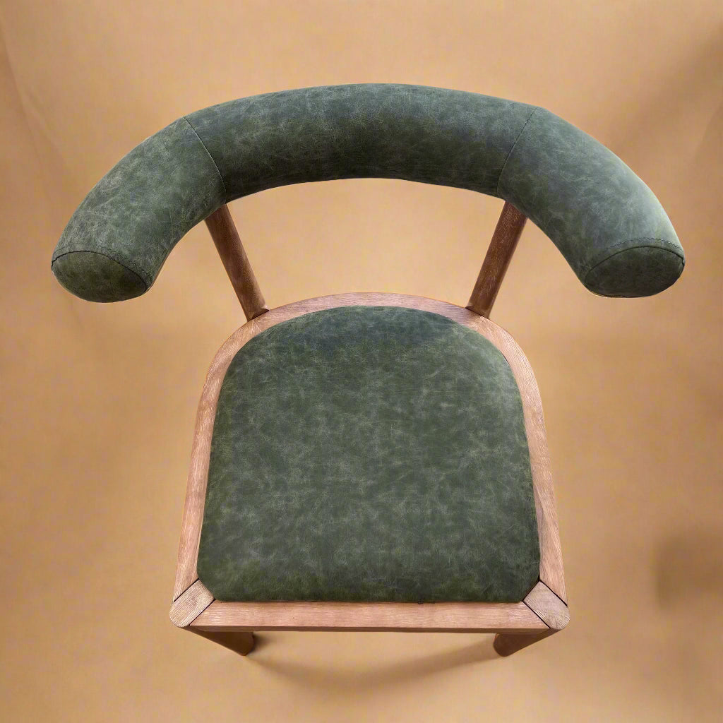 overview of green vegan leather dining chair with curved ergonomic backrest for circular table