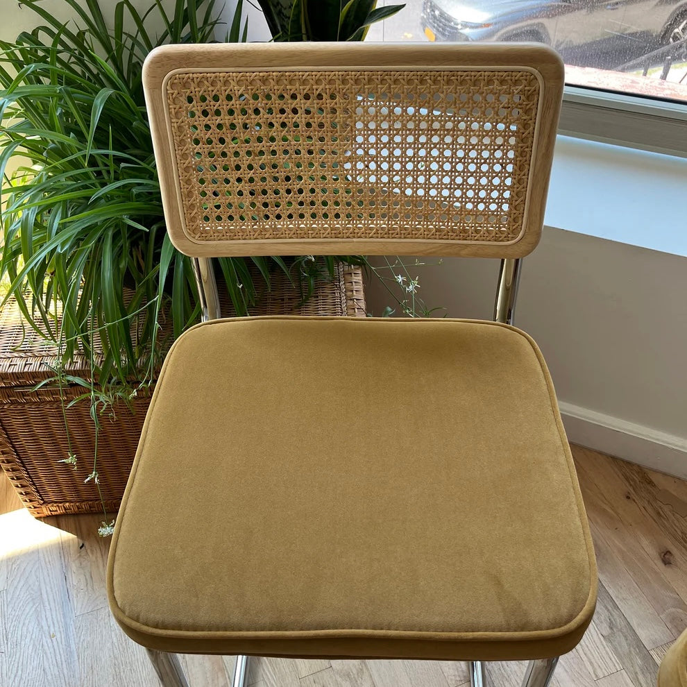 overview of counter height bar stool with yellow mustard velvet seat and solid wood seat back with rattan accents